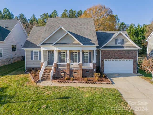 view of front of home featuring a front lawn, a porch, and a garage