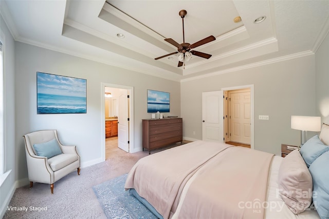 bedroom with ensuite bath, ceiling fan, a raised ceiling, light carpet, and ornamental molding