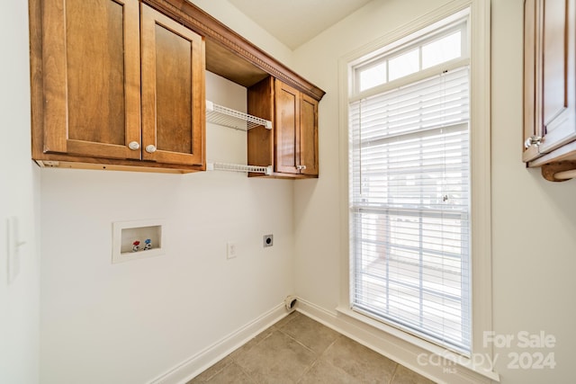 clothes washing area with electric dryer hookup, cabinets, light tile patterned floors, and hookup for a washing machine