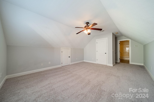 additional living space featuring ceiling fan, light colored carpet, and vaulted ceiling