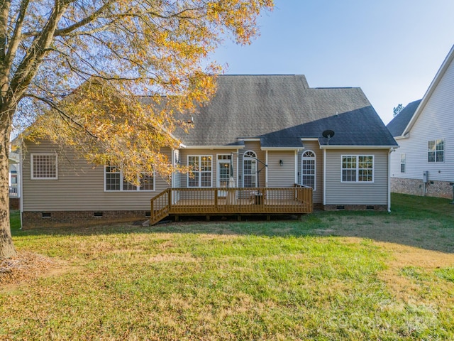 rear view of property featuring a lawn and a wooden deck