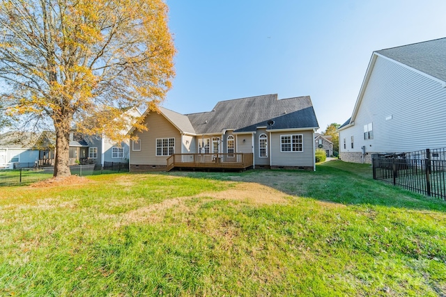 rear view of house with a yard and a wooden deck