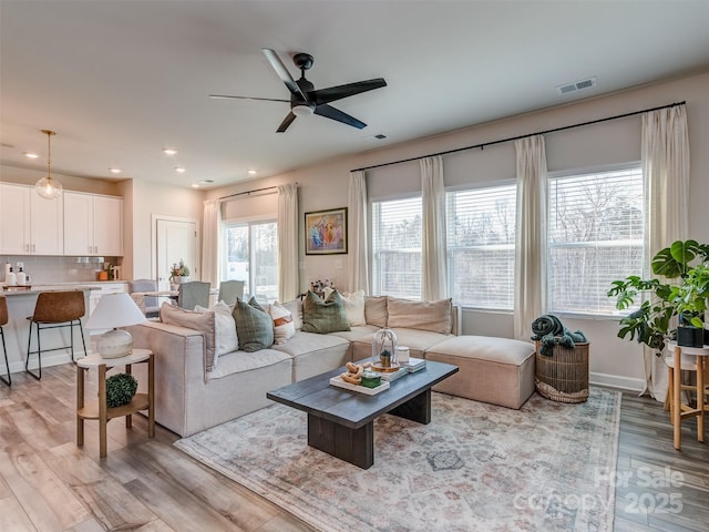 living room with ceiling fan and light hardwood / wood-style floors