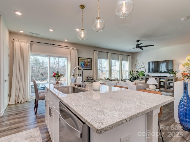 kitchen with pendant lighting, sink, stainless steel dishwasher, light stone counters, and white cabinetry