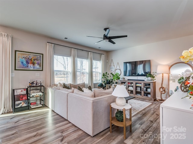 living room featuring light wood-type flooring and ceiling fan