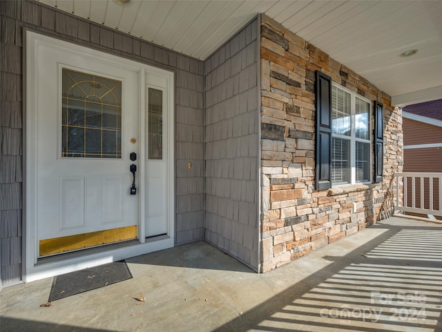 view of exterior entry featuring covered porch