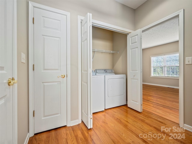 clothes washing area featuring light hardwood / wood-style floors