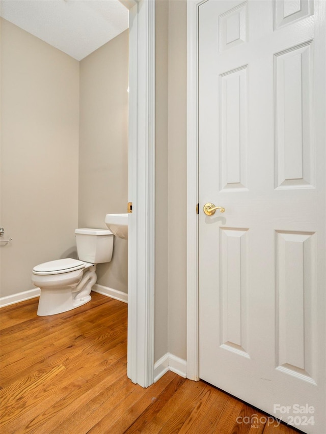 bathroom with toilet and wood-type flooring