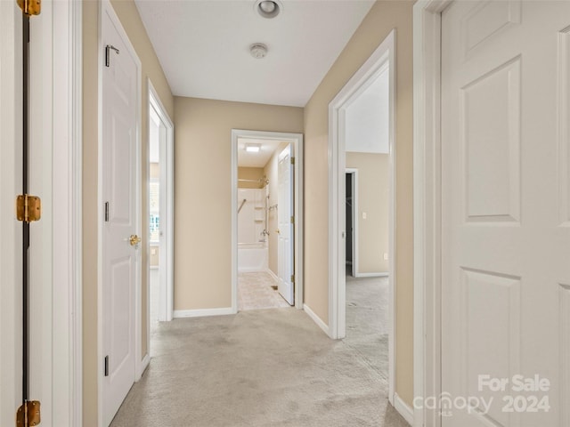 hall with light colored carpet