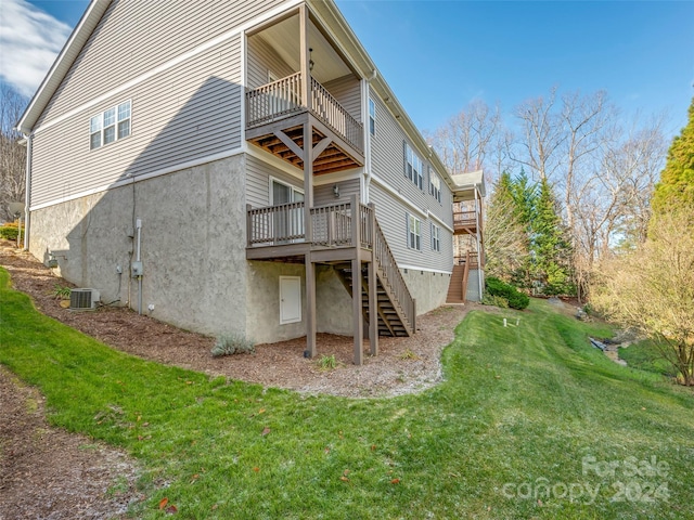 rear view of property with a lawn, cooling unit, and a deck