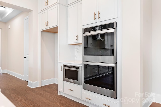 kitchen featuring white cabinets, dark hardwood / wood-style floors, and double oven