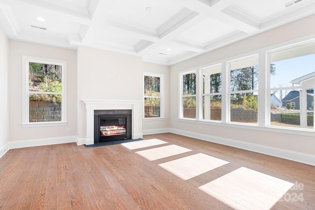 unfurnished living room featuring beam ceiling, light hardwood / wood-style floors, ornamental molding, and coffered ceiling