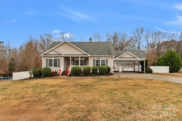 ranch-style home featuring a carport, a porch, and a front yard