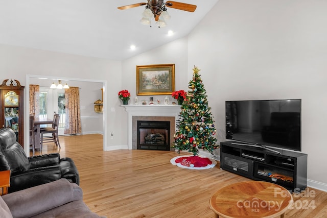 living room with a fireplace, hardwood / wood-style flooring, ceiling fan, and lofted ceiling