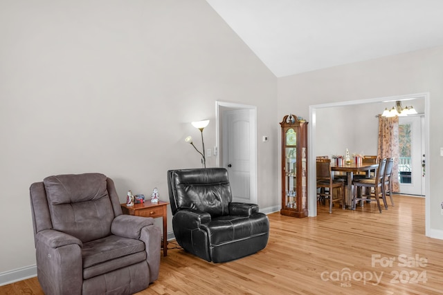 sitting room featuring high vaulted ceiling and hardwood / wood-style flooring