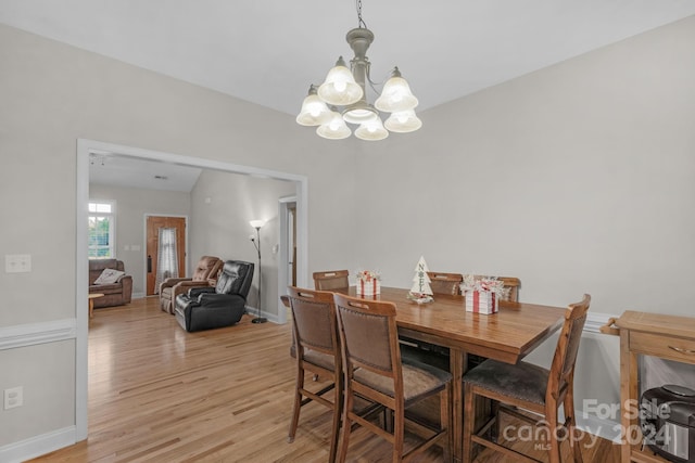 dining room with vaulted ceiling, a notable chandelier, and light wood-type flooring