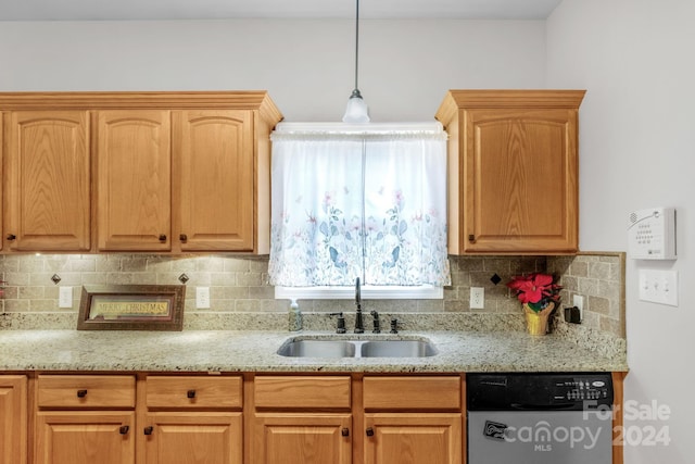 kitchen featuring pendant lighting, dishwasher, sink, and tasteful backsplash