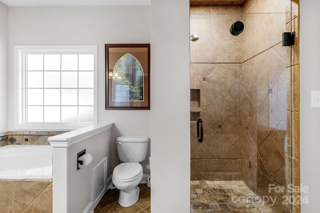 bathroom with tile patterned flooring, toilet, independent shower and bath, and a wealth of natural light