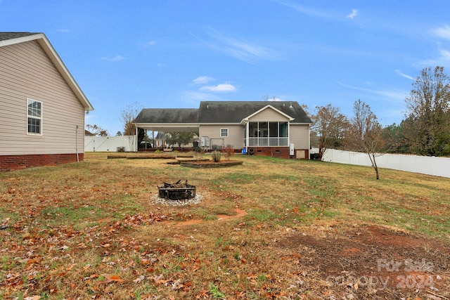 rear view of property with a sunroom and a yard