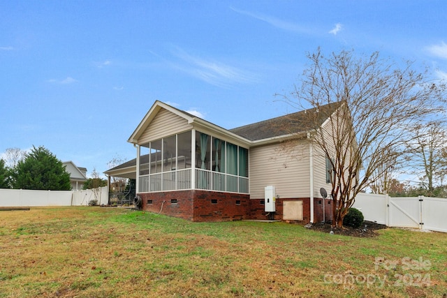 back of property featuring a lawn and a sunroom