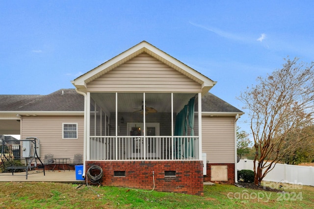 rear view of house featuring a sunroom, a patio area, and a yard