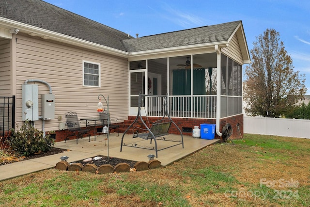 rear view of house with a yard, a patio, and a sunroom