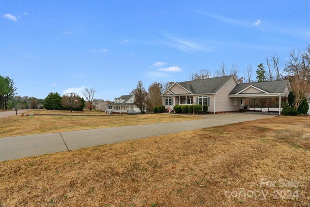 view of front of property with a carport and a front lawn