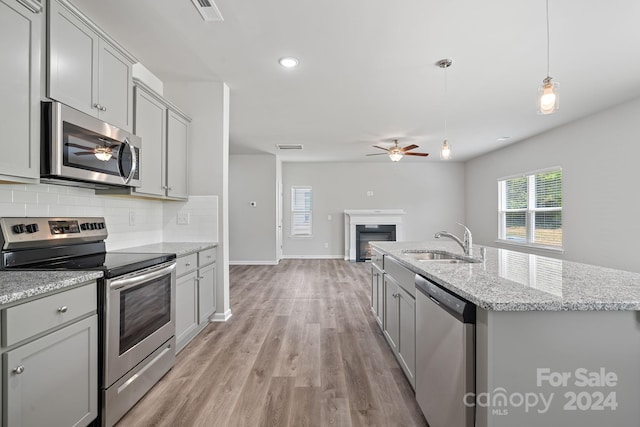 kitchen with gray cabinets, sink, light hardwood / wood-style floors, and appliances with stainless steel finishes