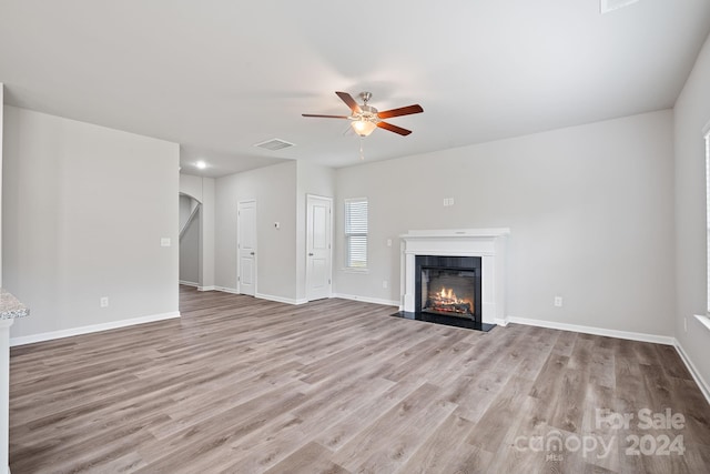 unfurnished living room featuring ceiling fan and light hardwood / wood-style floors