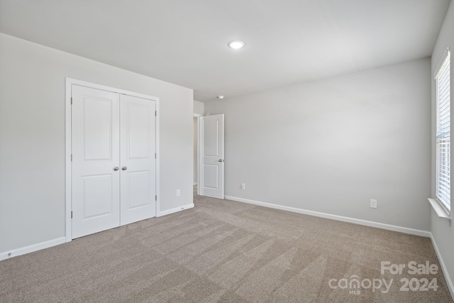 unfurnished bedroom with carpet flooring and a closet