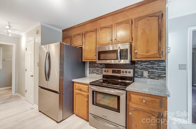 kitchen with backsplash, light hardwood / wood-style floors, stainless steel appliances, and ornamental molding