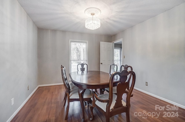 dining space featuring dark hardwood / wood-style floors and a notable chandelier