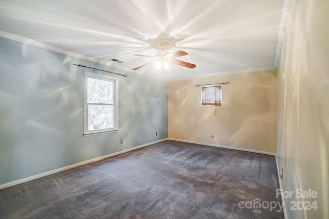 empty room with dark colored carpet, ceiling fan, and ornamental molding