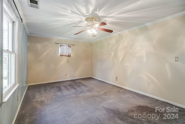 spare room featuring ceiling fan, dark carpet, and ornamental molding