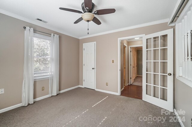 unfurnished bedroom with dark colored carpet, french doors, ceiling fan, and crown molding