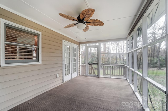 unfurnished sunroom featuring ceiling fan