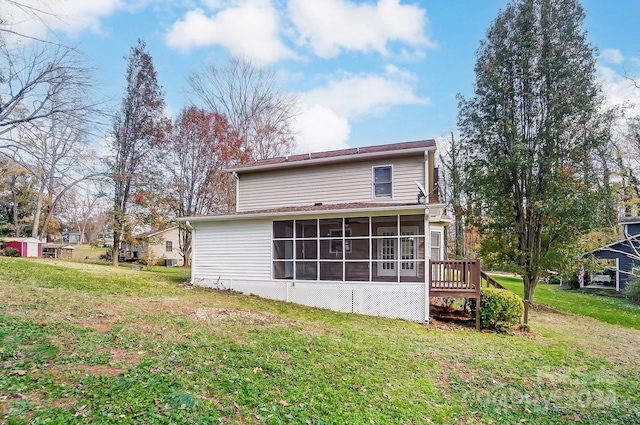 back of property featuring a lawn and a sunroom