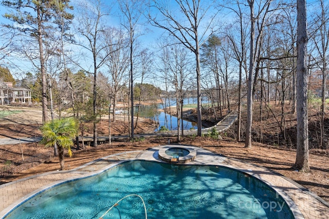 view of pool featuring an in ground hot tub and a water view