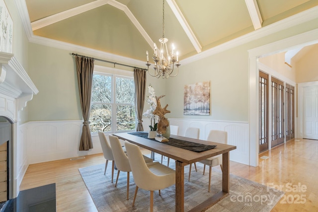 dining area with crown molding, high vaulted ceiling, a notable chandelier, beamed ceiling, and light hardwood / wood-style floors