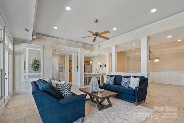 living room featuring ceiling fan, ornamental molding, and ornate columns