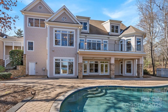 rear view of property featuring a patio area and a balcony