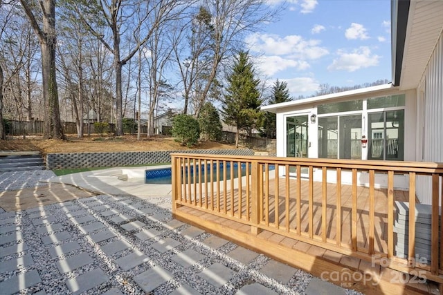 wooden deck with a pool and a patio