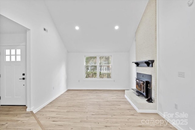 unfurnished living room featuring lofted ceiling and light hardwood / wood-style floors