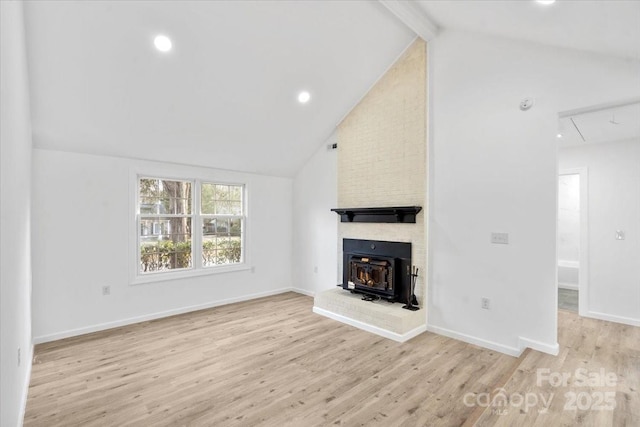 unfurnished living room with vaulted ceiling with beams and light wood-type flooring