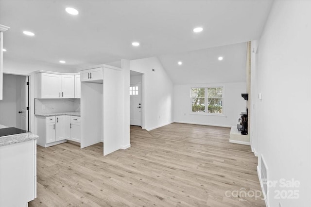 unfurnished living room with light hardwood / wood-style flooring and vaulted ceiling