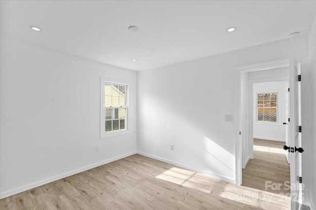 spare room with a healthy amount of sunlight and light hardwood / wood-style flooring