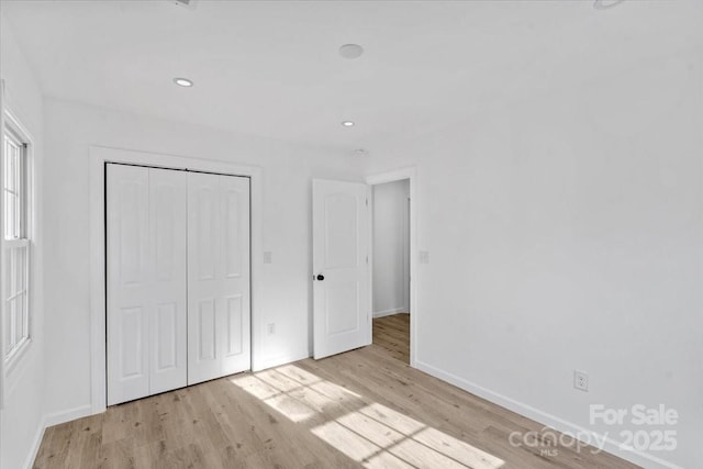 unfurnished bedroom featuring light hardwood / wood-style flooring and a closet