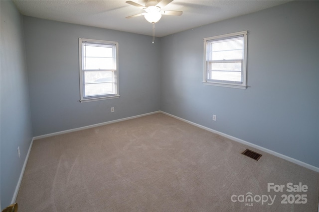 carpeted spare room with ceiling fan