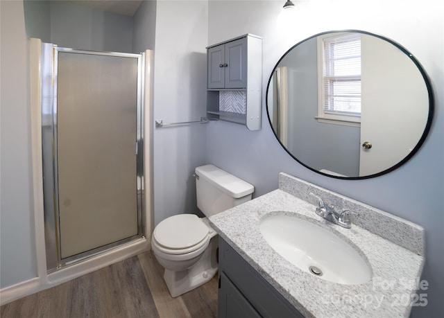 bathroom with wood-type flooring, vanity, toilet, and walk in shower