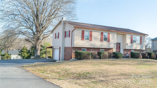 split foyer home featuring a front yard and a garage